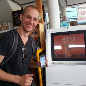 Een reiziger bij een Bitcoin ATM in Thailand