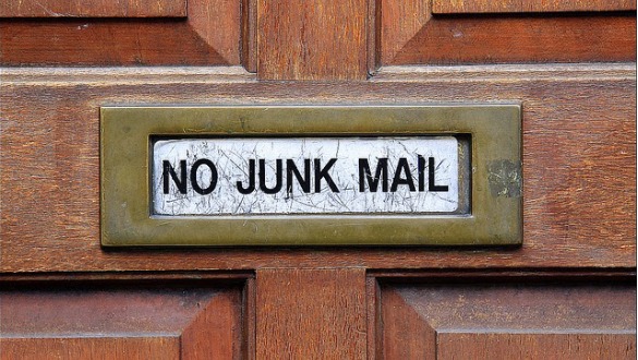 Een afbeelding van een deur met op de brievenbus 'no junk mail'.