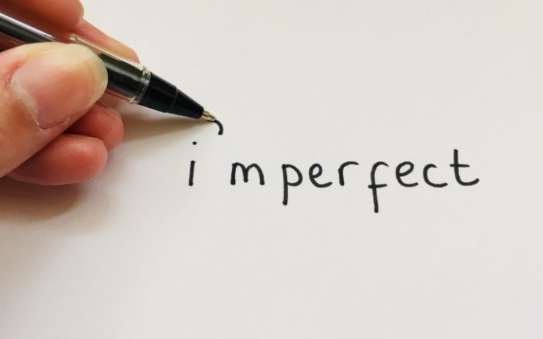 Hand met pen schrijft imperfect