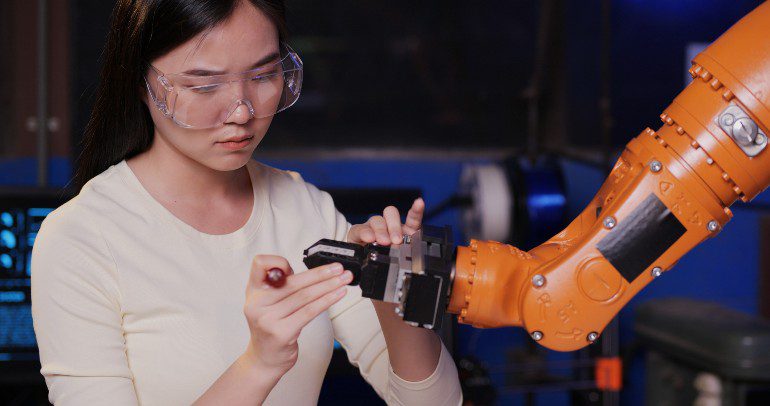 Vrouw werkt aan robotarm.