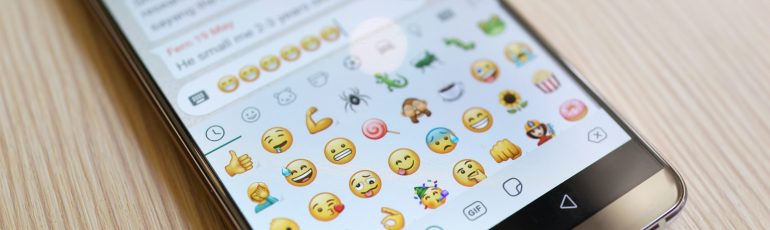 Emoji's op telefoon bij artikel over emoji in zakelijke communicatie