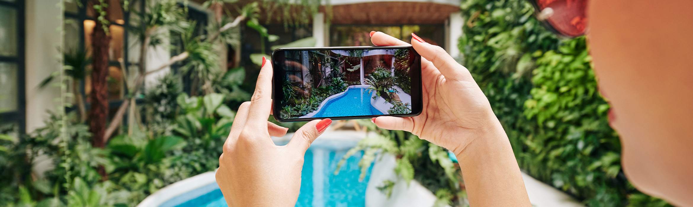 Smartphone met camera gericht op tropisch zwembad om content voor social media te maken