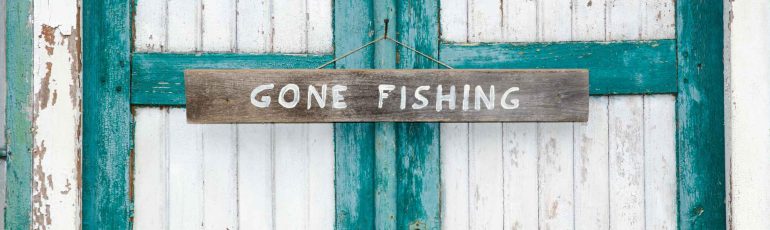 Gone fishing bord op deur ter illustratie van out-of-office zijn