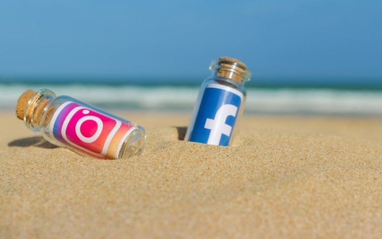 Logos Instagram en Facebook in glazen fles op het strand - Bron tanuha2001 _ Shutterstock.com