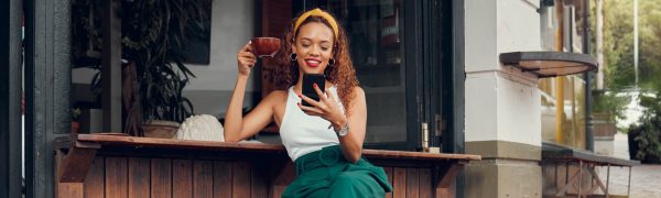 Vrouw in zakelijke outfit met koffie en telefoon ter illustratie van B2B-influencer marketing