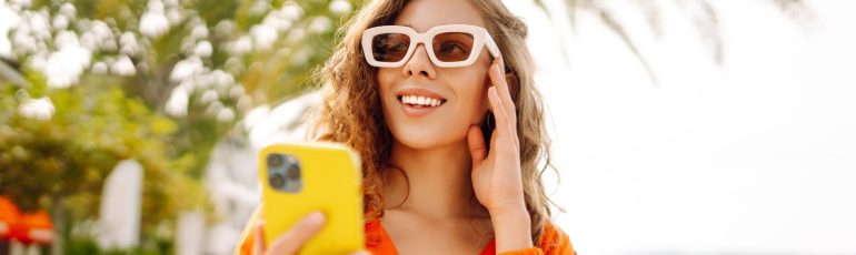 Vrouw met zonnebril en gele smartphone ter illustratie van SEO en social media