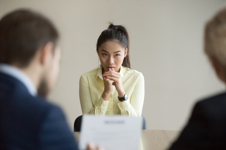 Aziatische vrouw nerveus tijdens HR-gesprek.