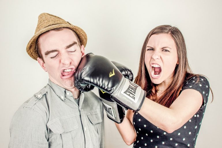 Vrouw slaat man zacht met een boxhandschoen 