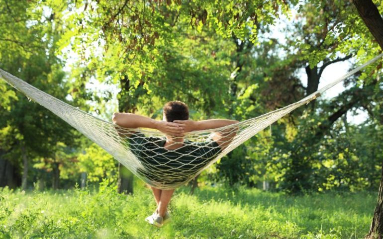 Man relaxed in hangmat in groene omgeving ter illustratie van slow productivity